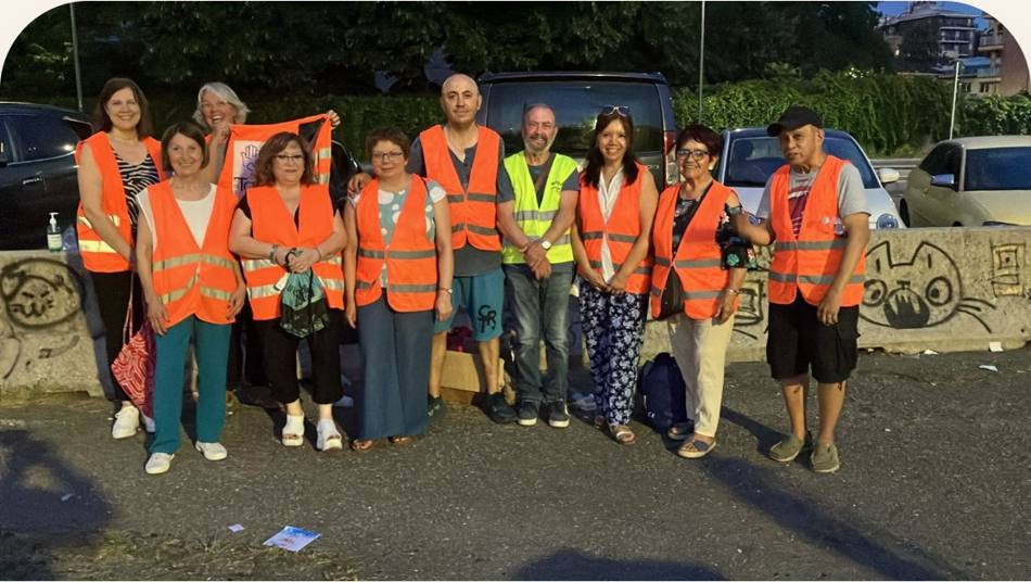 Volontarie e volontari di Amici di Tabita con gilet arancioni a Milano